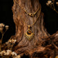 The gold sunburst necklace with Tiger's Eye draped vertically over a piece of dark textured wood.