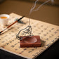 Incense burner with a smoking stick on an open book with Chinese characters