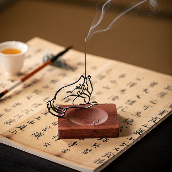 Incense burner with a smoking stick on an open book with Chinese characters