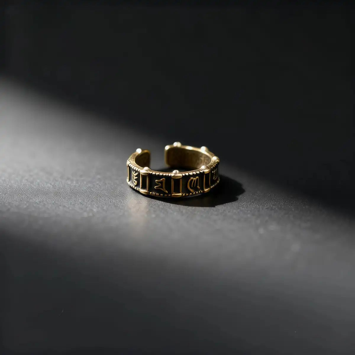 Close-up view of vintage six-word mantra open ring showing engraved symbols and metal texture