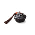 Ceramic lotus pod mini incense burner with dark glaze, lotus-shaped lid, brown tassel, and red bead, symbolizing stillness and clarity.