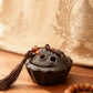 Incense burner with tassel and beads on a wooden surface