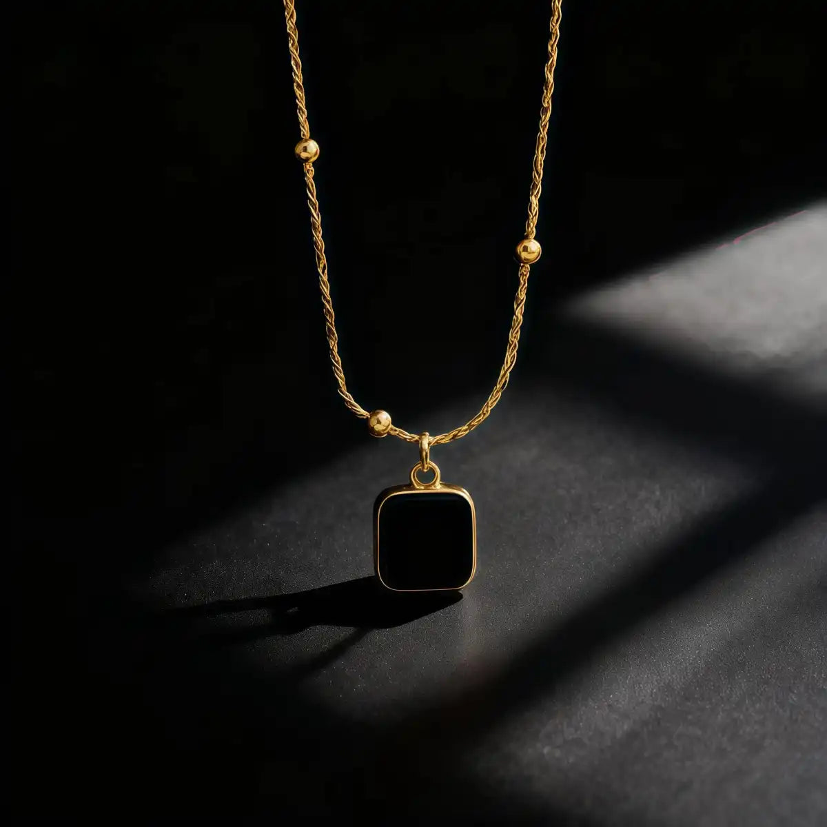 Black CZ cube pendant necklace displayed on a clean background, showing its sleek geometric design and polished shine.