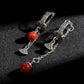 Tibetan Silver earrings with red beads on a dark textured surface