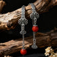 Tibetan Silver earrings with red beads on a wooden branch background