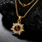 Gold necklace with a sun-shaped pendant featuring a brown tiger-eye gemstone on a dark textured background.