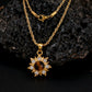 Gold necklace with a sun-shaped pendant on a dark textured background