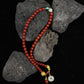 Red beaded Tibetan Blessing Bracelet with colorful accents on dark rocks