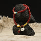 Tibetan Blessing bracelet with red and gold beads on a black stone against a dark background