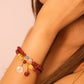 Close-up of a person's arm wearing a colorful Tibetan Blessing Bracelet on a plain background