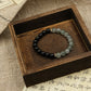 Protection Renewal Spiritual ClarityBracelet with black and green beads on a wooden box with text in the background