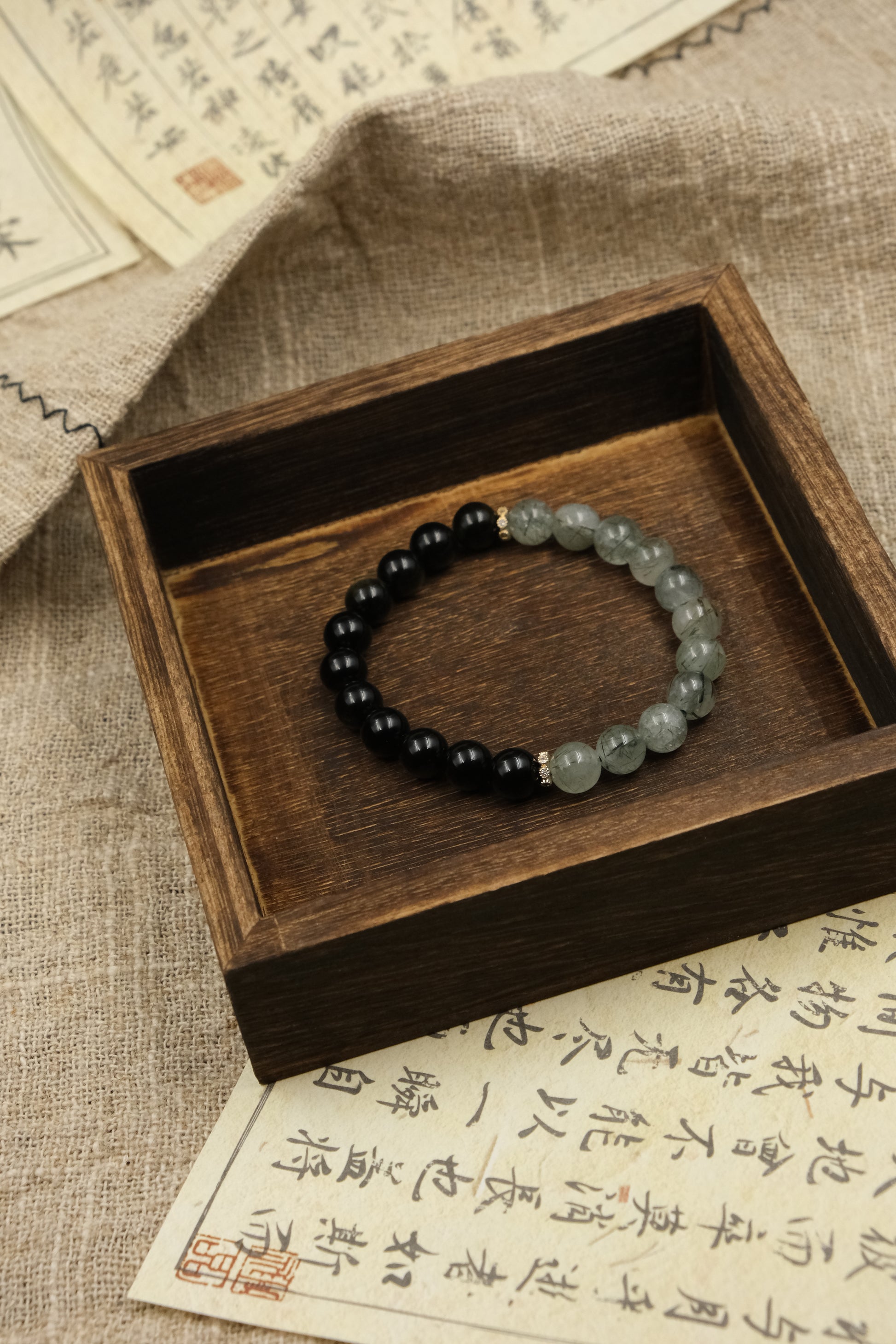 Protection Renewal Spiritual ClarityBracelet with black and green beads on a wooden box with text in the background