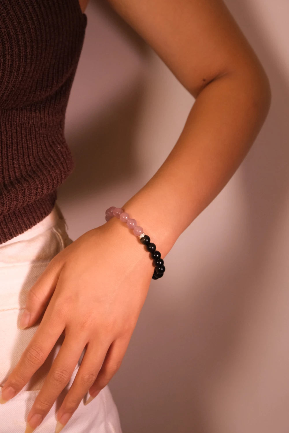Person wearing a Love & Harmony – Tibetan Dual Energy Bracelet with black beads on a neutral background