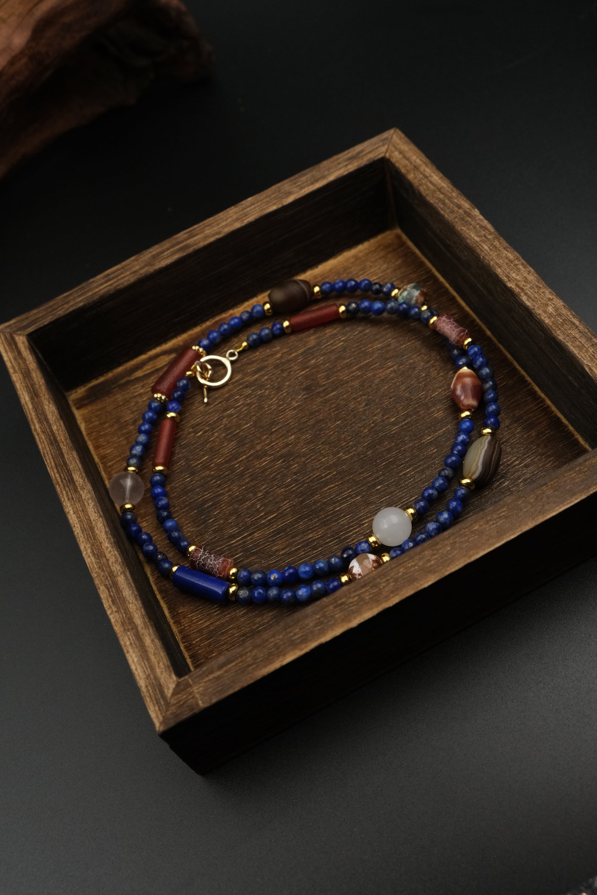 Lapis Lazuli & Amber Tibetan Energy Healing Bracelet on a wooden box with a dark background