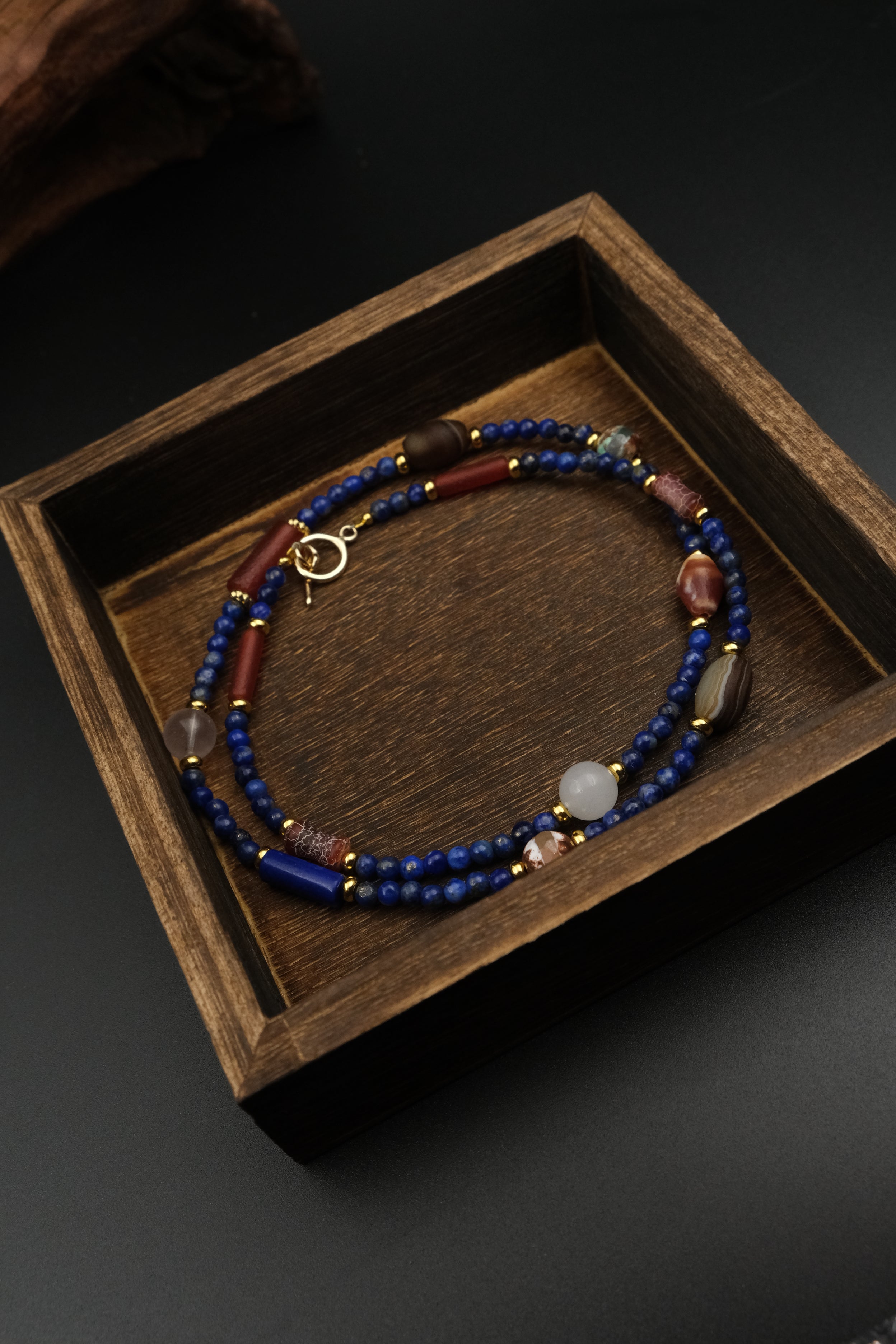 Lapis Lazuli & Amber Tibetan Energy Healing Bracelet on a wooden box with a dark background