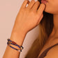 Woman wearing a Luck & Healing – Tibetan Energy Mala Bracelet with beads on a plain background, Lapis Lazuli & Amber