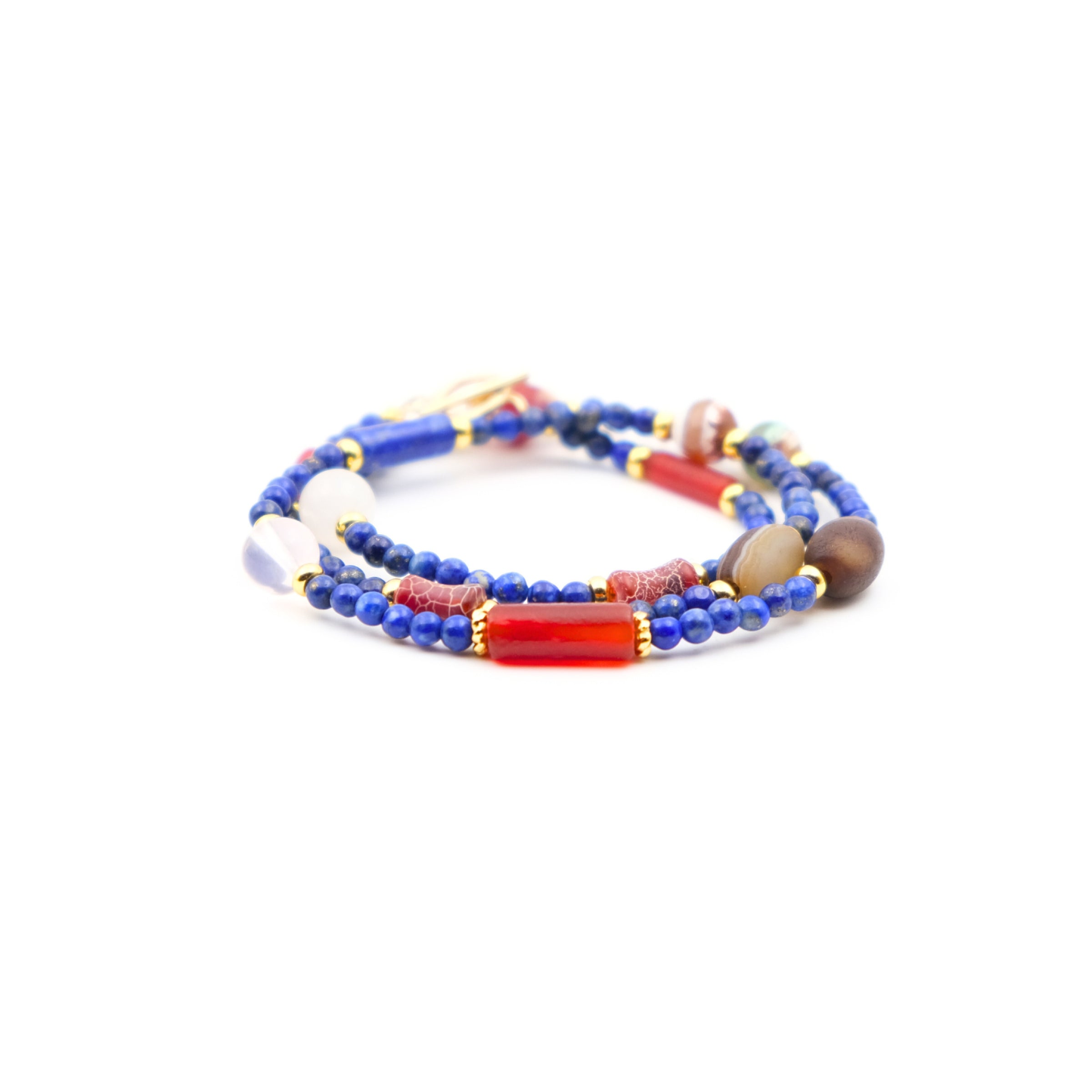 A Tibetan Energy Healing Bracelet / Mala composed of multiple strands. It features vibrant blue lapis lazuli beads interspersed with various other beads, including white, red, and brown ones, along with a striking red - hued bead. There are also golden accents between the beads. This bracelet is believed to bring luck, offer protection, and facilitate healing. 