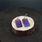 Focus & Balance – Tibetan Amethyst Earrings on a wooden stand with a dark background