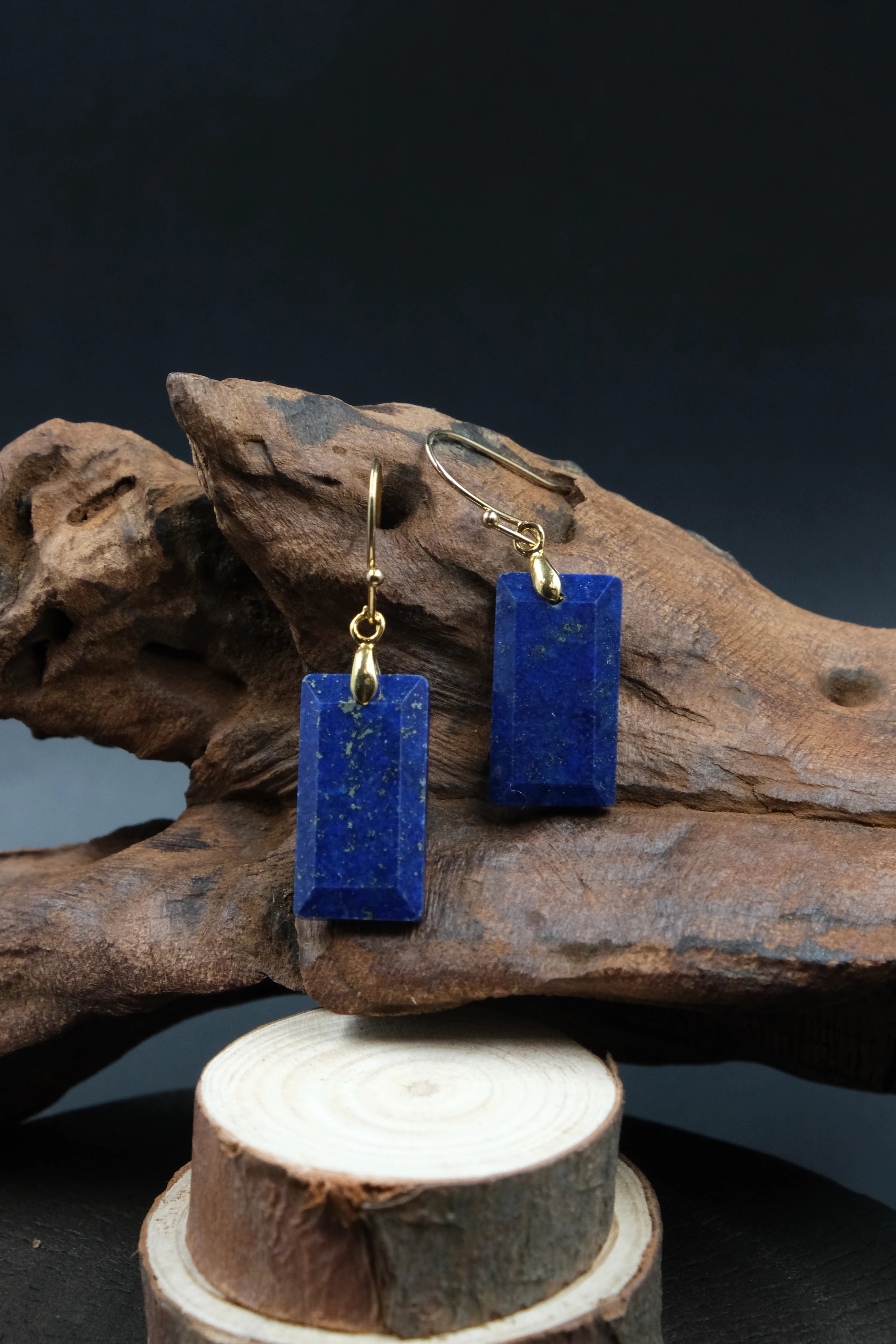 Blue rectangular earrings on a wooden stand with a dark background, Tibetan Feng Shui Crystal Earrings – Lapis Lazuli for Protection, Purification & Well-Being