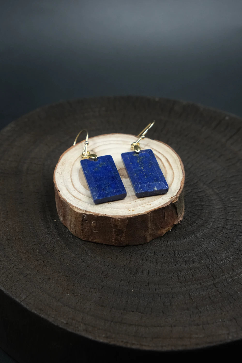 Blue rectangular earrings on a wooden stand with a dark background, Tibetan Feng Shui Crystal Earrings – Lapis Lazuli for Protection, Purification & Well-Being