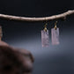 Handcrafted Tibetan Feng Shui Rose Quartz Crystal Earrings with healing energy for romance, social luck, and heart chakra balance, displayed on a branch