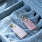 Pink crystal earrings with gold hooks on a blue velvet jewelry box