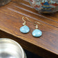 Confidence & Renewal Tibetan Amazonite Earrings on a wooden surface with decorative bowls in the background