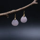 Tibetan Feng Shui Drop Earrings – Rose Quartz for Love, Social Connection & Emotional Healing with gold hooks on a dark background