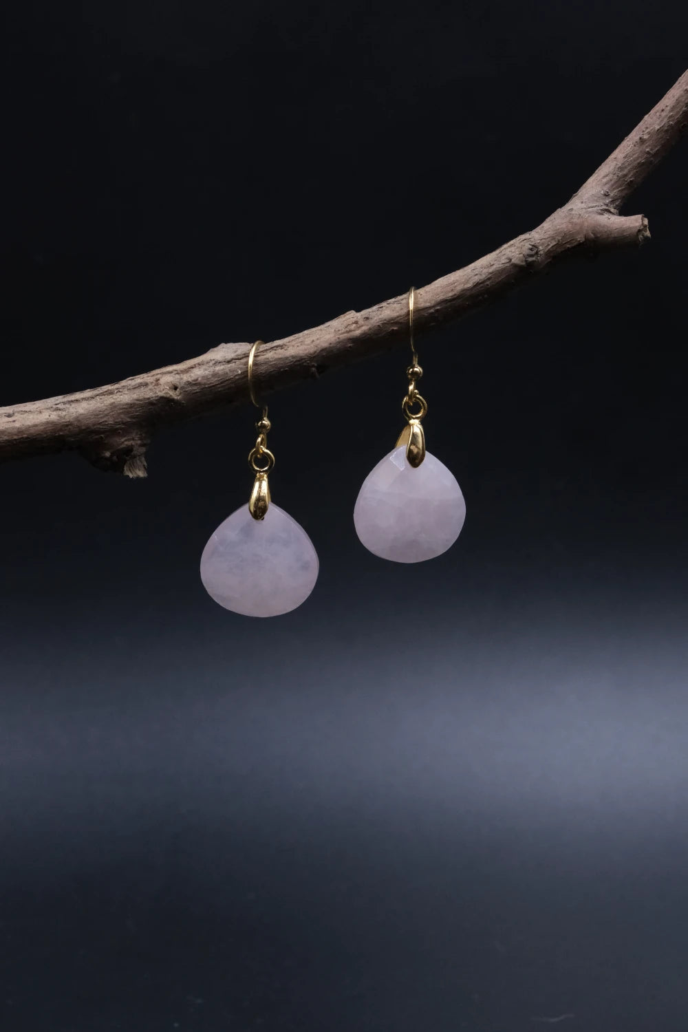 Tibetan Feng Shui Drop Earrings – Rose Quartz for Love, Social Connection & Emotional Healing with gold hooks on a dark background