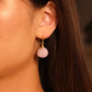 Close-up of an ear wearing Tibetan Feng Shui Drop Earrings – Rose Quartz for Love, Social Connection & Emotional Healing