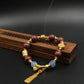 Tibetan Five Elements Aromatherapy Bracelet with beads and gold accents on a dark background,Cleansing Inner Balance