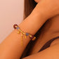 Close-up of a wrist wearing a Tibetan Five Elements Aromatherapy bracelet with beads and tassels on a neutral background