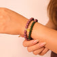 Close-up of a wrist wearing two-cycle Aromatherapy beaded bracelets on a plain background