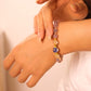 Close-up of a hand wearing a beaded bracelet on a plain background, Tibetan Five Elements Flow Bracelet – Blue Agate, Incense-Glass & Plum Blossom for Emotional Healing, Wealth Attraction & Spiritual Protection