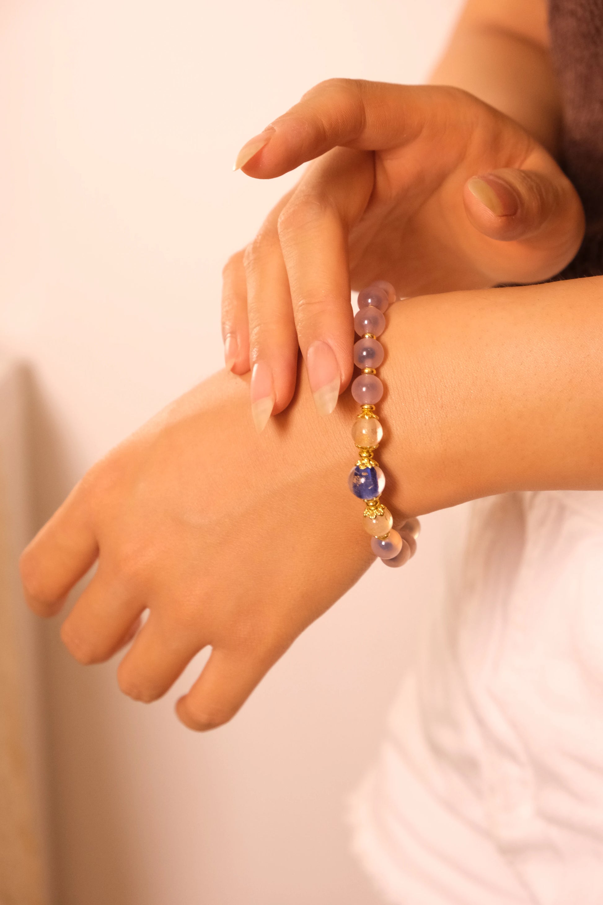 Close-up of a hand wearing a beaded bracelet on a plain background, Tibetan Five Elements Flow Bracelet – Blue Agate, Incense-Glass & Plum Blossom for Emotional Healing, Wealth Attraction & Spiritual Protection