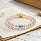 Bracelet with pink beads and gold accents on an open book