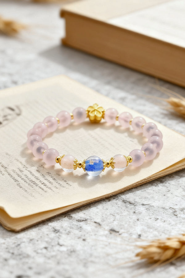Bracelet with pink beads and gold accents on an open book