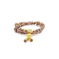A Tibetan Five Elements Flow Bracelet with two strands of purple foil ash - glass beads. It is embellished with a golden temple charm, which has a small decorative element featuring blue inlays above it. Hanging from the charm are two purple beads. This bracelet is believed to bring clarity, calmness, and spiritual insight. 
