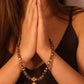 Woman with hands in prayer position wearing a Tibetan Five Elements Flow Bracelet
