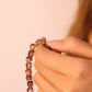 Hand holding a Calm & Insight Tibetan Five Elements Flow Bracelet against a plain background