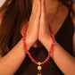 Person wearing a Vitality & Prosperity  Tibetan Five Elements Flow Bracelet with hands in prayer position against a neutral background