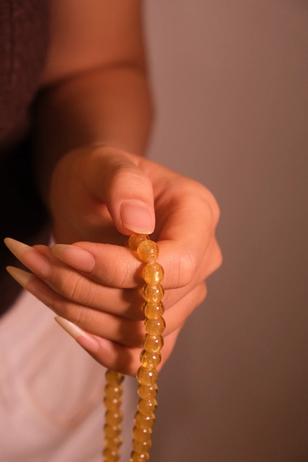 Hand holding a Clarity & Wisdom Tibetan Five Elements Flow Bracelet against a neutral background