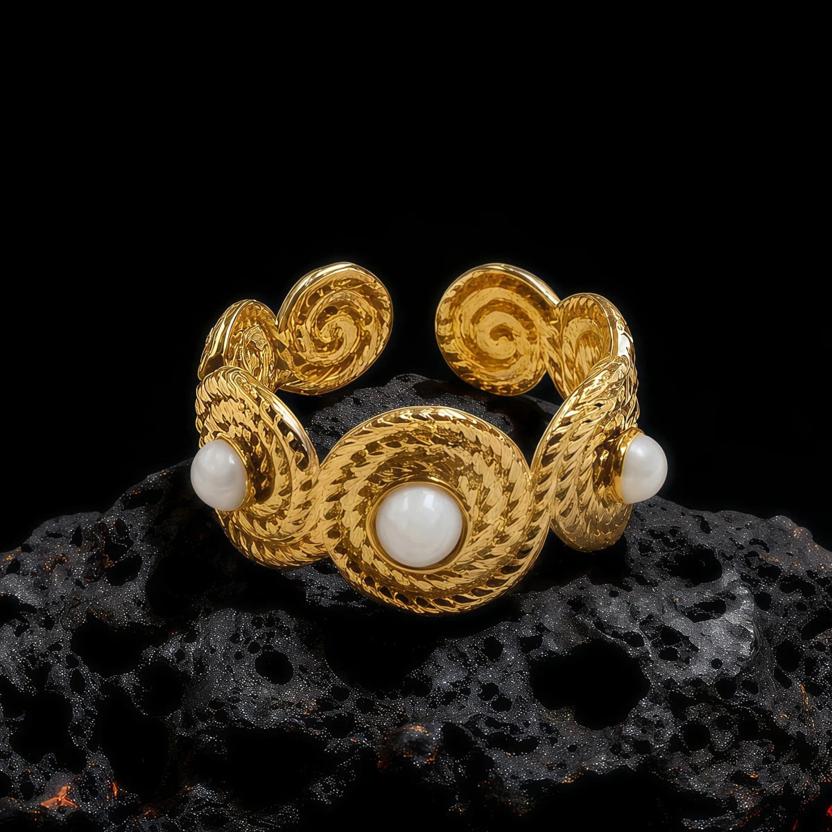 A gold-toned Tibetan Five Elements ring featuring a central white pearl and intricate spiral patterns, resting on a dark volcanic rock, symbolizing the harmonious flow of the five elements and inner peace.