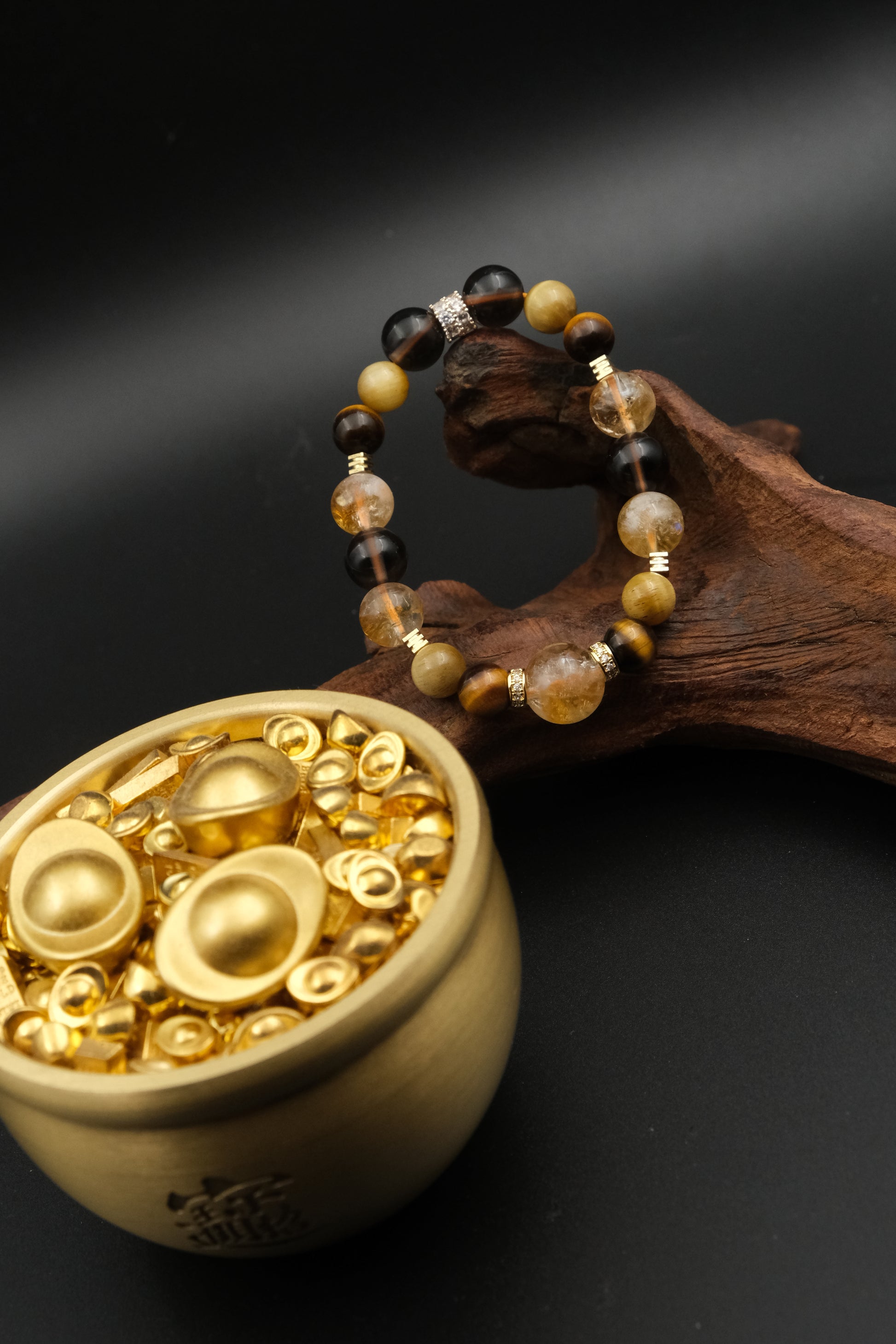 Tibetan Goldwish Crystal Bracelet with gold and black beads on a dark background