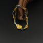 Luxury handmade gold and blue beaded bracelet with woven cord, double round gold charm, and turquoise accents.