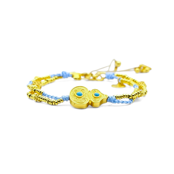 A Tibetan Harmony Double Bracelet featuring a golden gourd charm adorned with turquoise accents, strung with blue cord and golden beads, symbolizing luck and protection.