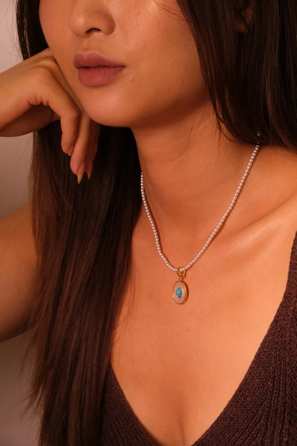 Model wearing handcrafted Tibetan Harmony Pendant Necklace featuring glowing mother-of-pearl and natural pearls, associated with spiritual balance, feminine energy, and healing harmony.