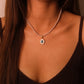 Model wearing handcrafted Tibetan Harmony Pendant Necklace featuring glowing mother-of-pearl and natural pearls, associated with spiritual balance, feminine energy, and healing harmony.