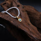 Handcrafted Tibetan Harmony necklace featuring a polished turquoise heart pendant with pearl beads, associated with protection and emotional balance, displayed on wooden surface.