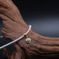 Handcrafted Tibetan Harmony necklace featuring a polished turquoise heart pendant with pearl beads, associated with protection and emotional balance, displayed on wooden surface.